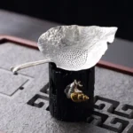 antique leaf shape tin tea strainer with tree stump stand full view