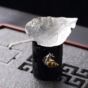 antique leaf shape tin tea strainer with tree stump stand full view