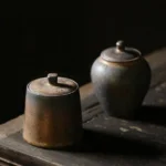 antique style ceramic tea canister with antiqued bronze finish displayed on wooden background