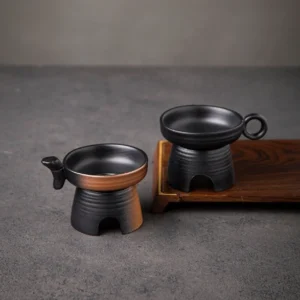 handcrafted black pottery traditional ding shape tea strainer on wooden tea table