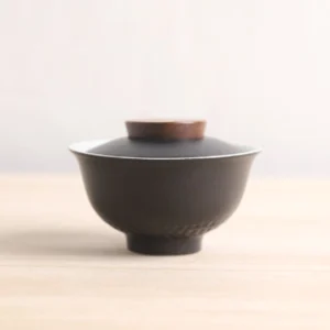 hammered textured black and white ceramic gaiwan with wood accent front view