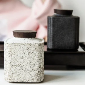 small sealed ceramic tea canister with wooden lid front view