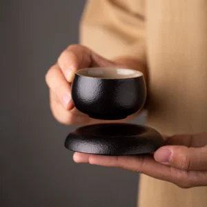 handcrafted chinese black clay tea cup and saucer set with textured matte finish
