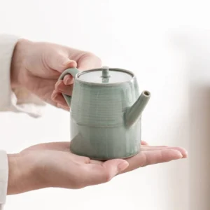 Handheld view of Chinese celadon glaze ceramic teapot 6.1oz