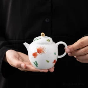 full side view of hand-painted chinese ceramic fish teapot white body with red goldfish motif