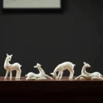 collection of white ceramic deer tea pet in different poses for gongfu tea table