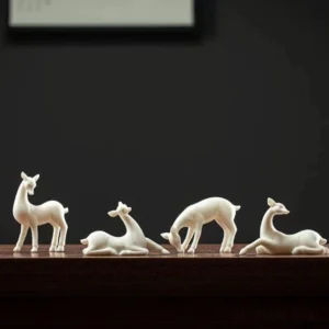 collection of white ceramic deer tea pet in different poses for gongfu tea table