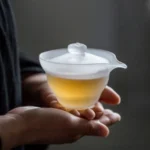 hand holding frosted glass gaiwan lidded tea bowl