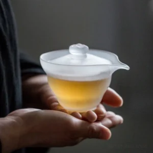 hand holding frosted glass gaiwan lidded tea bowl