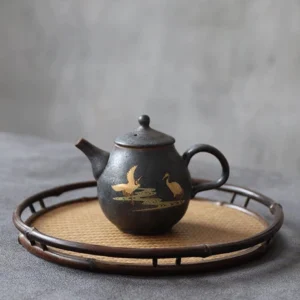 full side view of handmade chinese black ceramic teapot with golden crane pattern