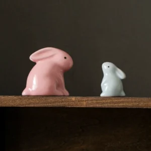 group of minimalist ceramic rabbit tea pets in pink and blue, different sizes displayed