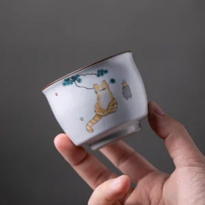 close up of hand-painted chinese tea cup against wooden background