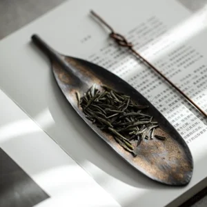 handcrafted ceramic bodhi leaf tea scoop held in hand