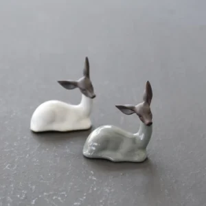 handcrafted ceramic deer tea pet resting on wooden tea table