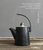 Handmade black ceramic chinese teapot with metal lift handle, front view