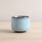 handmade blue ceramic chinese tea cup with ancient coin detail side view