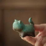 side view of handmade ceramic chubby cat tea pet on tea tray