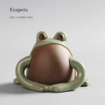 Handmade ceramic zisha frog tea pet on wooden tea table
