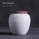 front view of mini white clay tea canister with brown lid