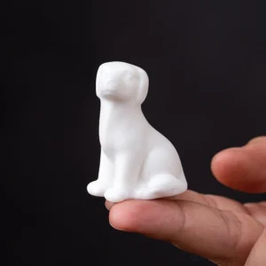 front view of mini white porcelain sitting dog tea pet