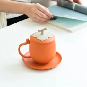 persimmon shaped ceramic tea mug with infuser lid and saucer full product view
