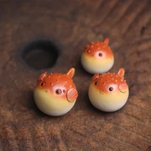 Set of 3 cute puffer fish tea pet displayed on wooden tea table