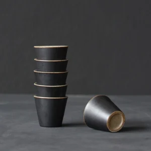 set of 6 rustic dark chinese ceramic tea cups stacked on wooden board
