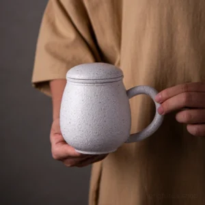 speckled white ceramic infuser tea mug with strainer lid, side view