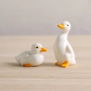 handcrafted white ceramic duck tea pet standing on wooden background