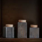 collection of vintage ceramic tea canisters with wooden lids in multiple shapes