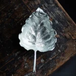 vintage leaf shaped tin tea strainer silver tone side view